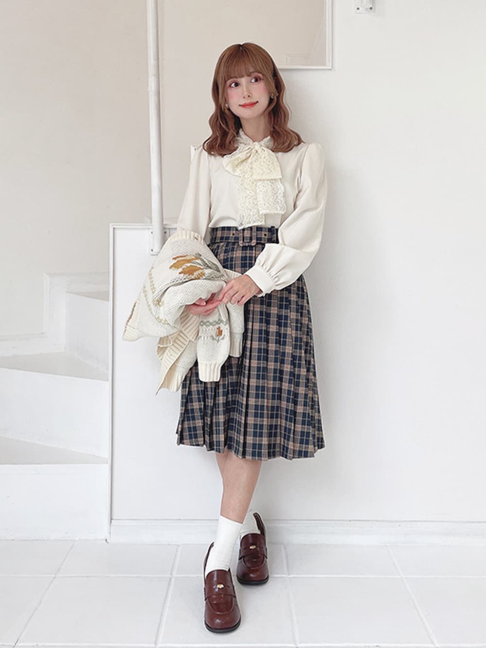 ブラウン系のローファー、ホワイト系のシャツ/ブラウス、グリーン系のスカートを着用したレディースの冬コーディネートの2枚目の写真