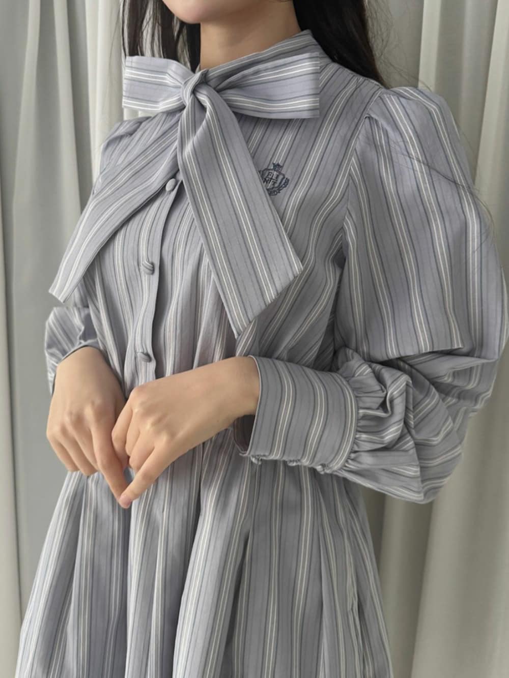 ブラック系のパンプス、グレー系のワンピース、レッド系のバレッタ/ヘアクリップを着用したレディースの冬コーディネートの3枚目の写真