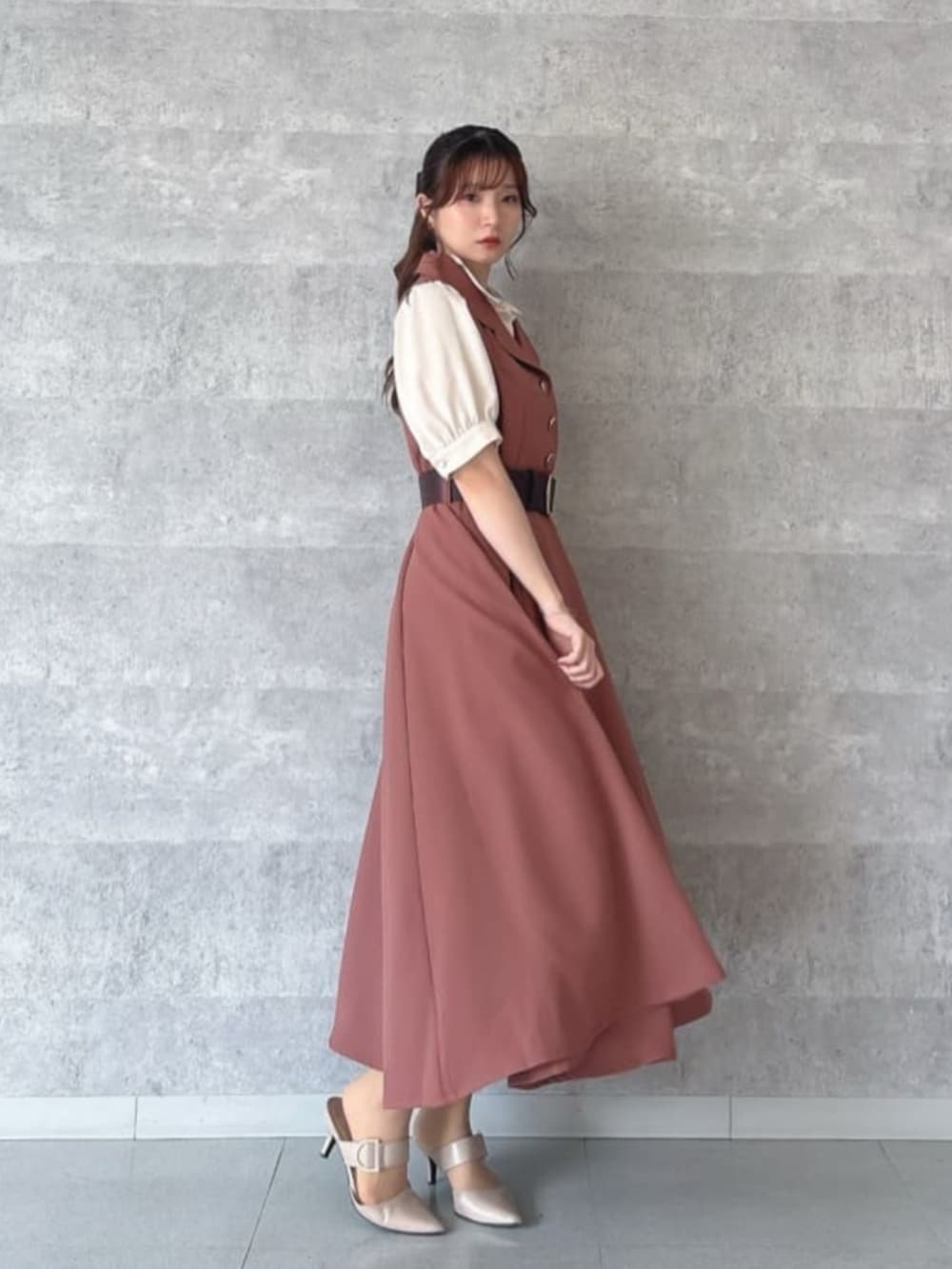 レッド系のハンドバッグ、レッド系のワンピース、ベージュ系のシャツ/ブラウスを着用したレディースの夏コーディネートの3枚目の写真