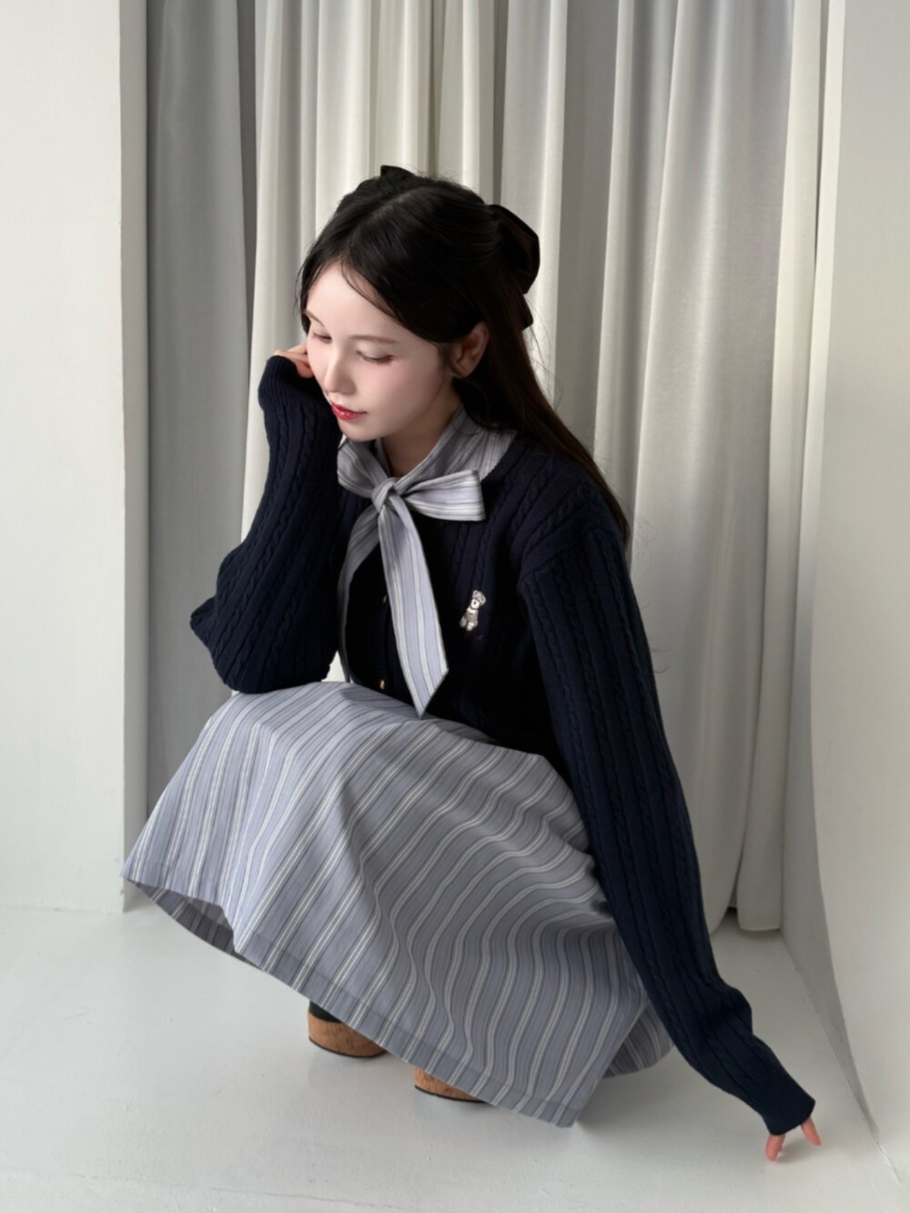 ブラック系のパンプス、ブルー系のカーディガン/ボレロ、ブラウン系のバレッタ/ヘアクリップを着用したレディースの冬コーディネートの2枚目の写真