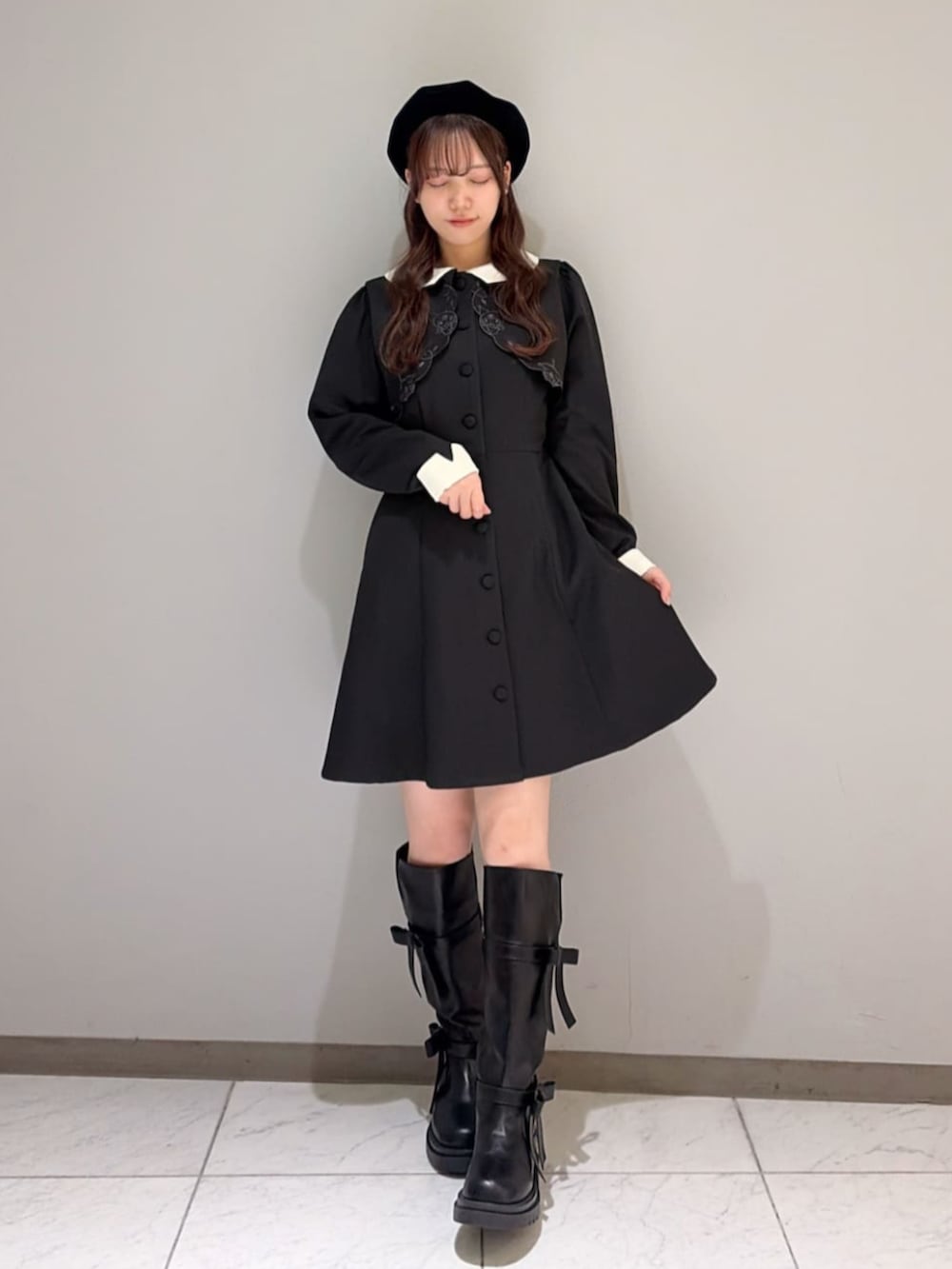ブラック系のブーツ、ブラック系のワンピース、ブラック系のハンチング/ベレー帽を着用したレディースの冬コーディネートの2枚目の写真