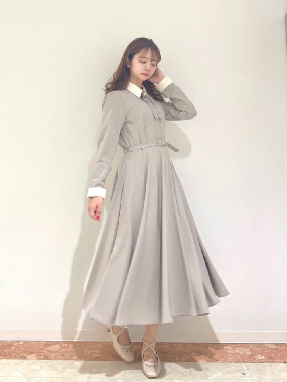 グレー系のワンピース、ホワイト系のパンプスを着用したレディースの秋コーディネートの3枚目の写真