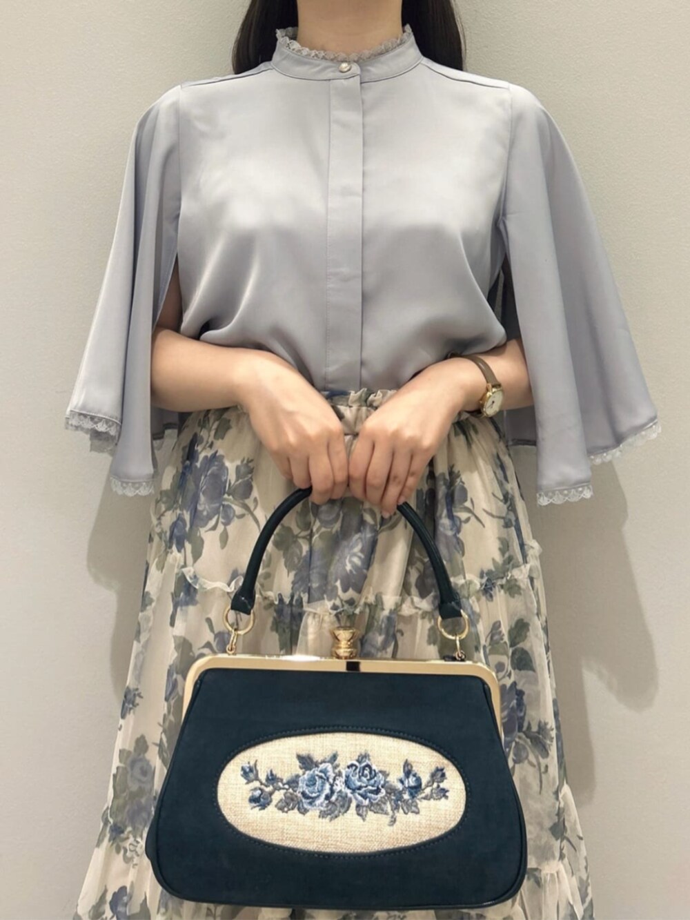 グレー系のシャツ/ブラウス、ブルー系のスカート、ブルー系のハンドバッグを着用したレディースの夏コーディネートの4枚目の写真
