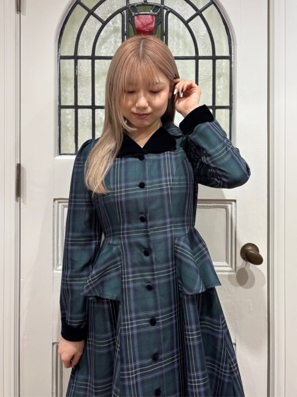 ブラック系のパンプス、ブラック系のハンドバッグ、グリーン系のワンピースを着用したレディースの秋コーディネートの2枚目の写真