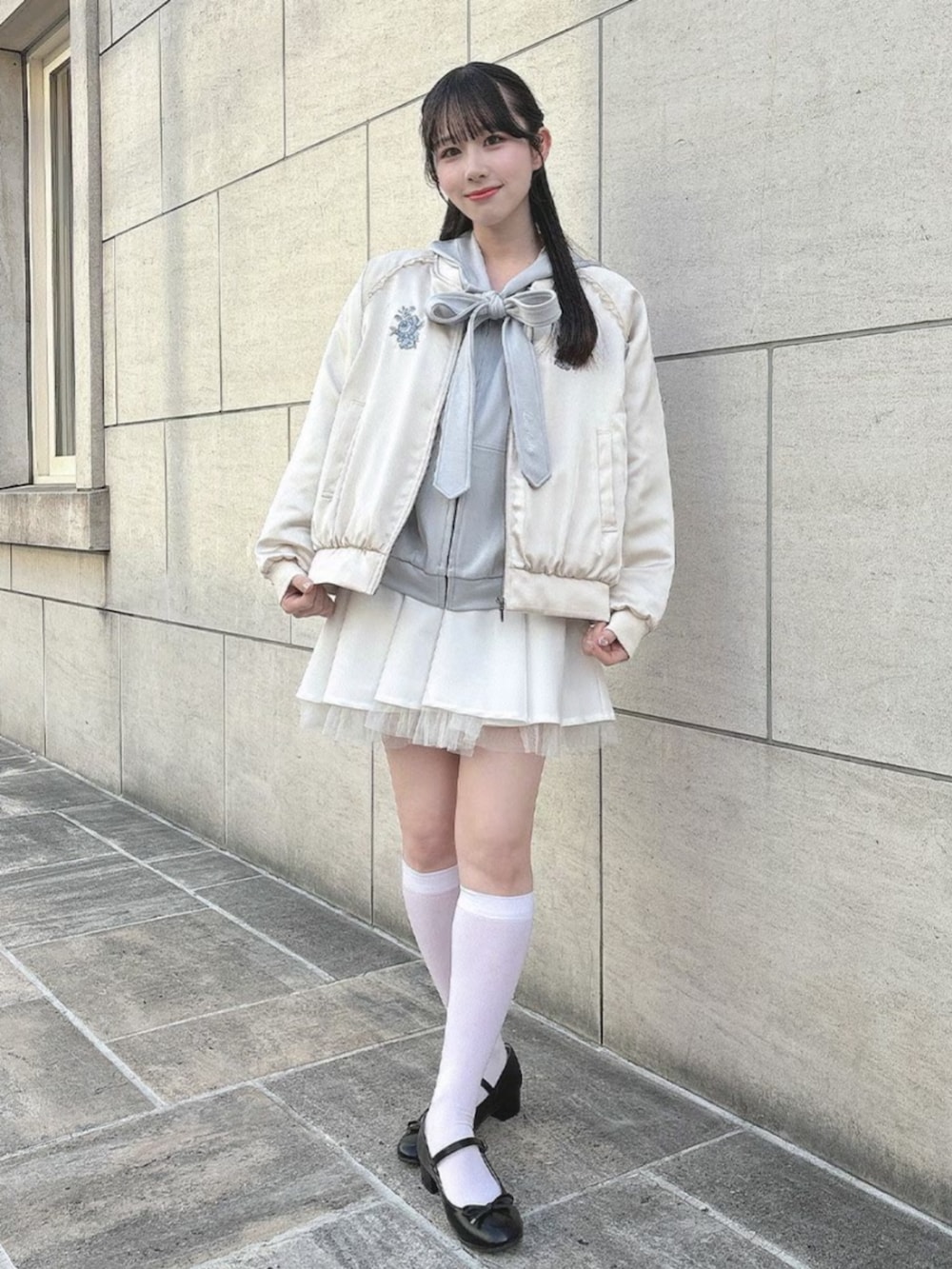 ホワイト系のスカート、ブラック系のバレエシューズ、ホワイト系のブルゾンを着用したレディースの春コーディネートの2枚目の写真