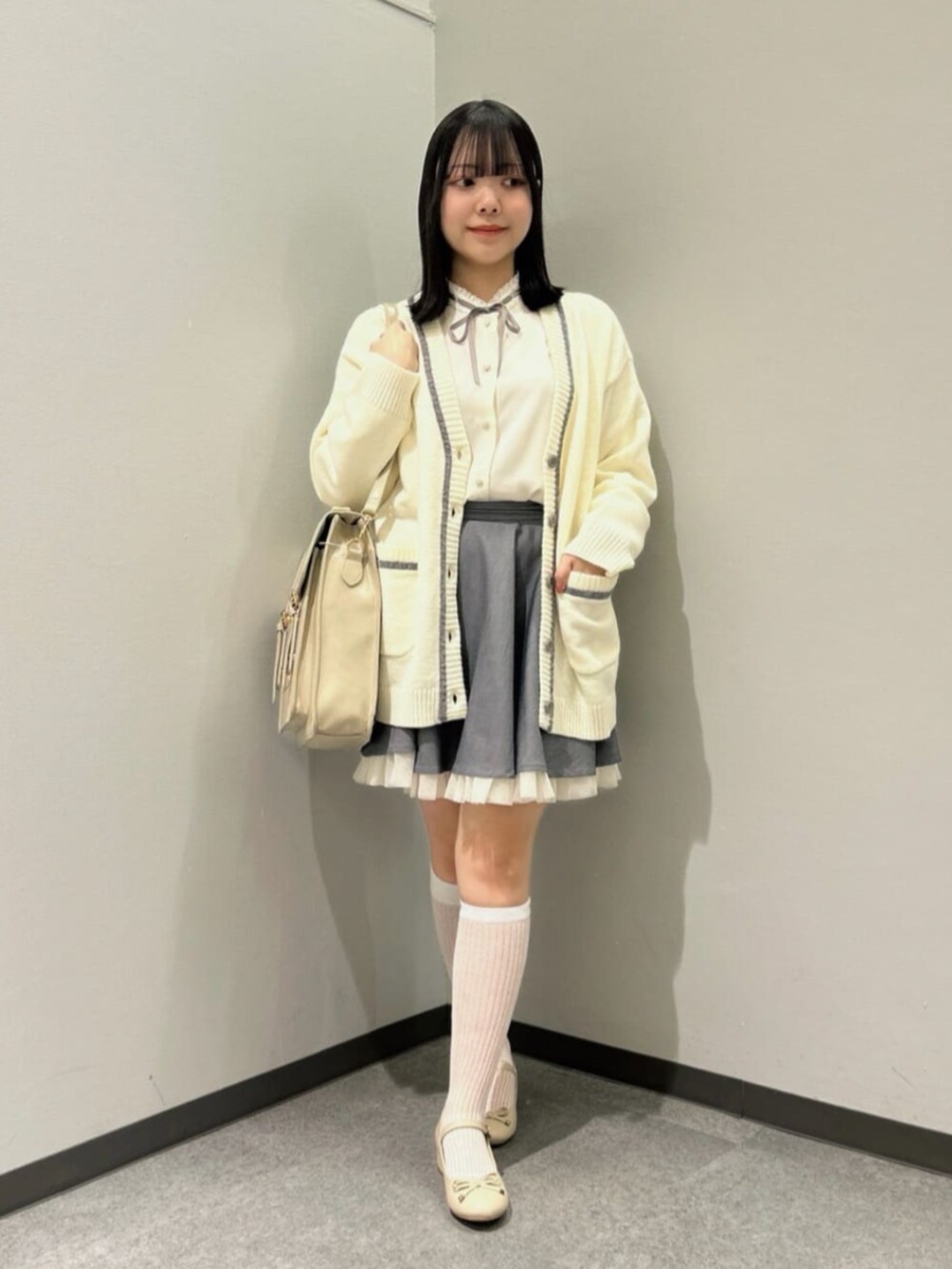 ホワイト系のカーディガン/ボレロ、ベージュ系のパンプス、ホワイト系のシャツ/ブラウスを着用したレディースの冬コーディネートの2枚目の写真