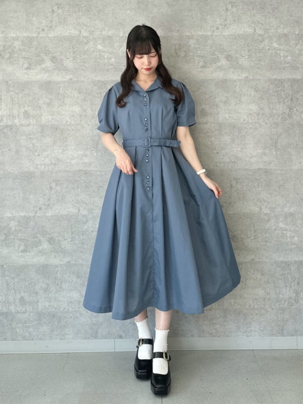 ブラック系のパンプス、ブルー系のシャツワンピース、ブラック系のハンドバッグを着用したレディースの夏コーディネートの2枚目の写真