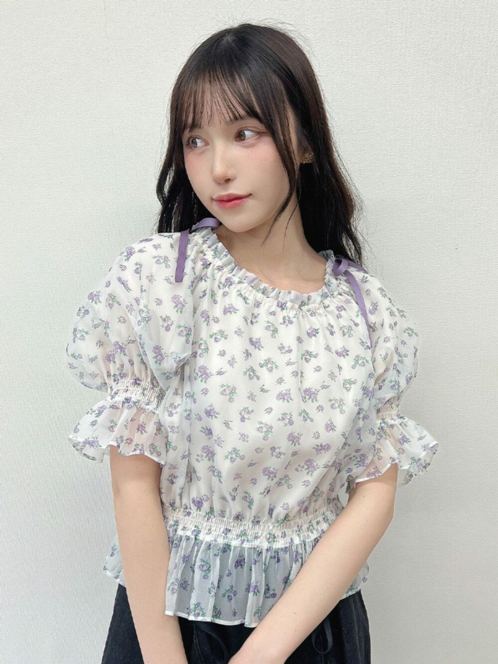 ホワイト系のスニーカー、ブラック系のデニムスカートを着用したレディースの春コーディネートの2枚目の写真