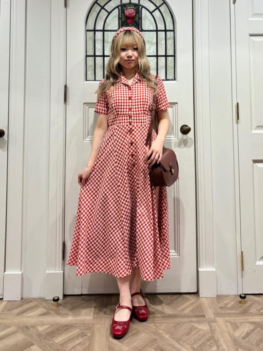 ホワイト系のワンピース、ブルー系のデニムジャケット、レッド系のパンプスを着用したレディースの春コーディネートの2枚目の写真