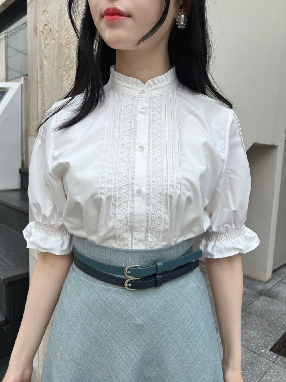 ブラウン系のパンプス、ホワイト系のシャツ/ブラウス、ブルー系のスカートを着用したレディースの春コーディネートの3枚目の写真