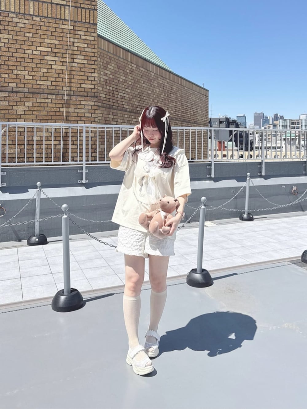 ホワイト系のサンダル、ホワイト系のセットアップ、ホワイト系のTシャツ/カットソーを着用したレディースの春コーディネートの3枚目の写真