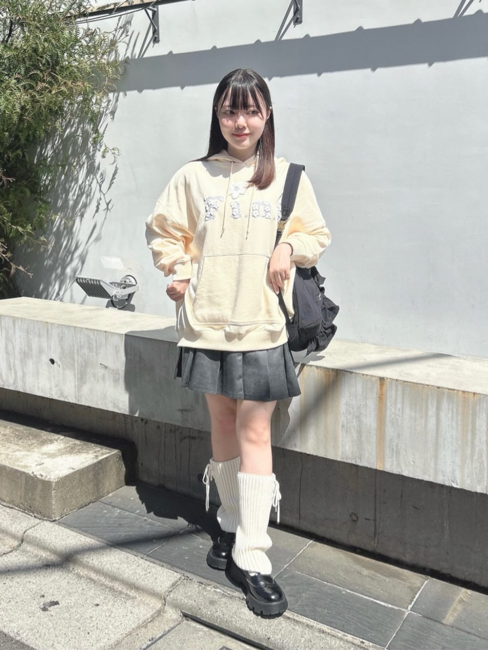 ホワイト系のパーカー、ブラック系のショルダーバッグ、グレー系のスカートを着用したレディースの秋コーディネートの2枚目の写真