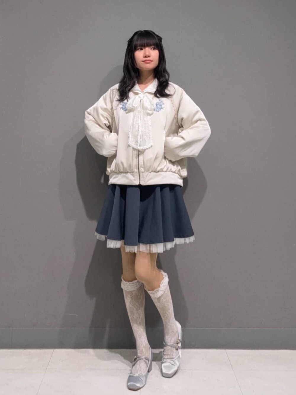 ブルー系のスカート、ホワイト系のシャツ/ブラウス、ホワイト系のブルゾンを着用したレディースの冬コーディネートの3枚目の写真