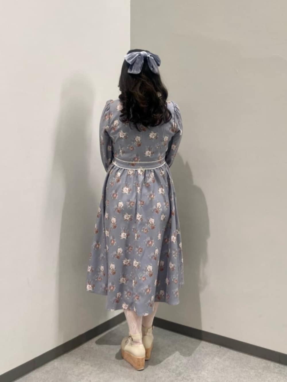 ホワイト系のパンプス、グレー系のワンピース、ピンク系のショルダーバッグを着用したレディースの冬コーディネートの2枚目の写真