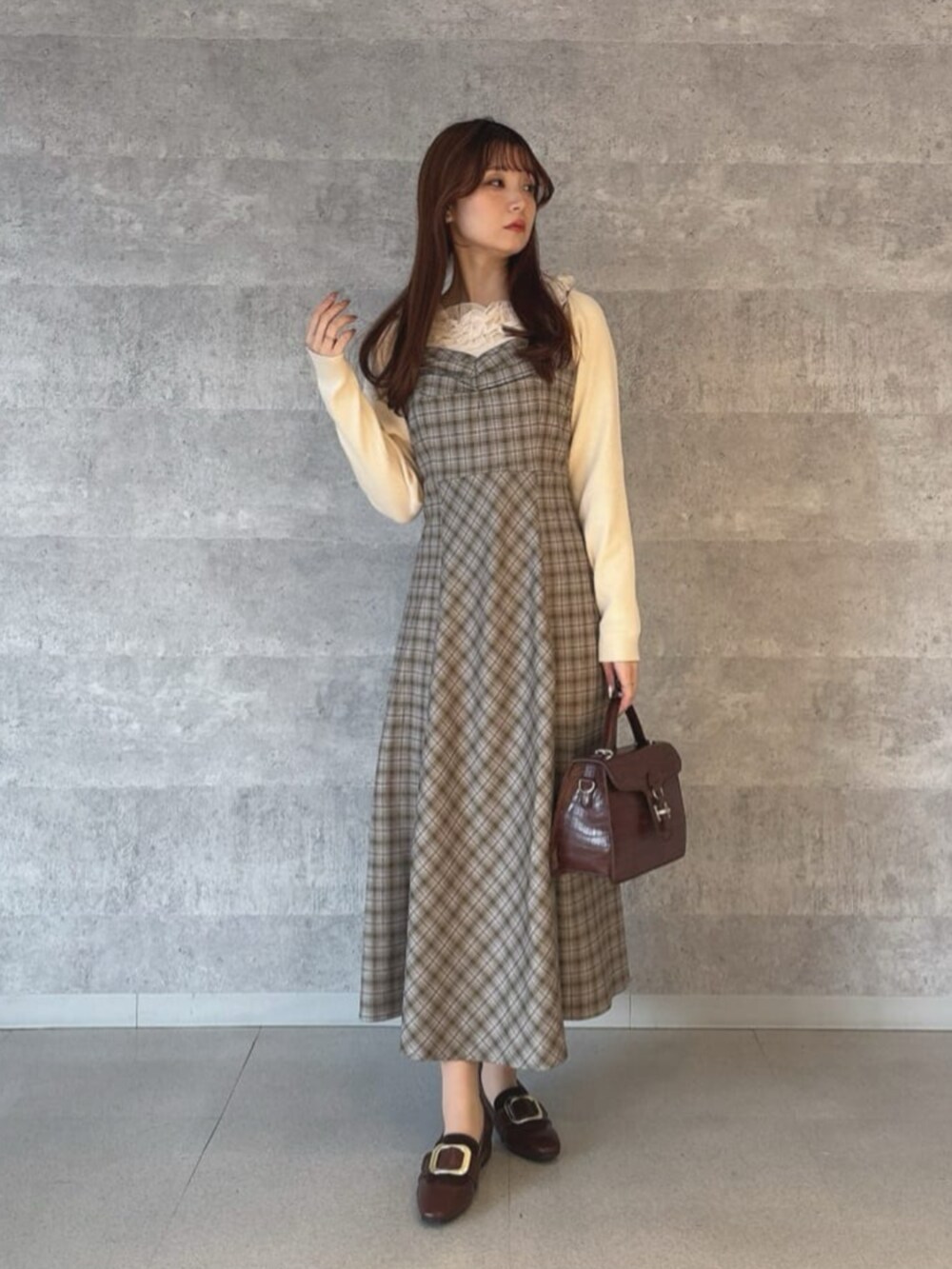 ブラウン系のその他シューズ、イエロー系のハンドバッグ、グレー系のワンピースを着用したレディースの冬コーディネートの2枚目の写真