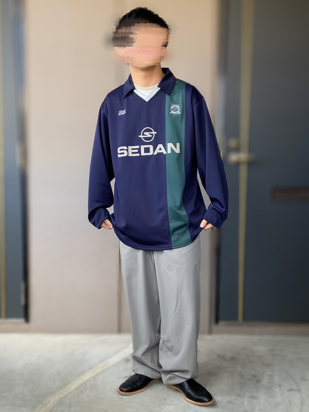 グレー系のトップス、ブラック系のシューズ、ブルー系のTシャツ/カットソーを着用したメンズの春コーディネートの2枚目の写真
