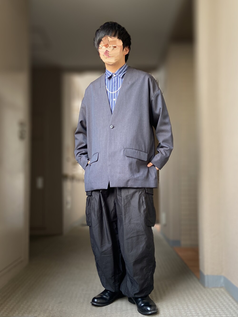 ブラック系のスリッポン、ブラック系のパンツ、ブルー系のテーラードジャケットを着用したメンズの秋コーディネートの2枚目の写真
