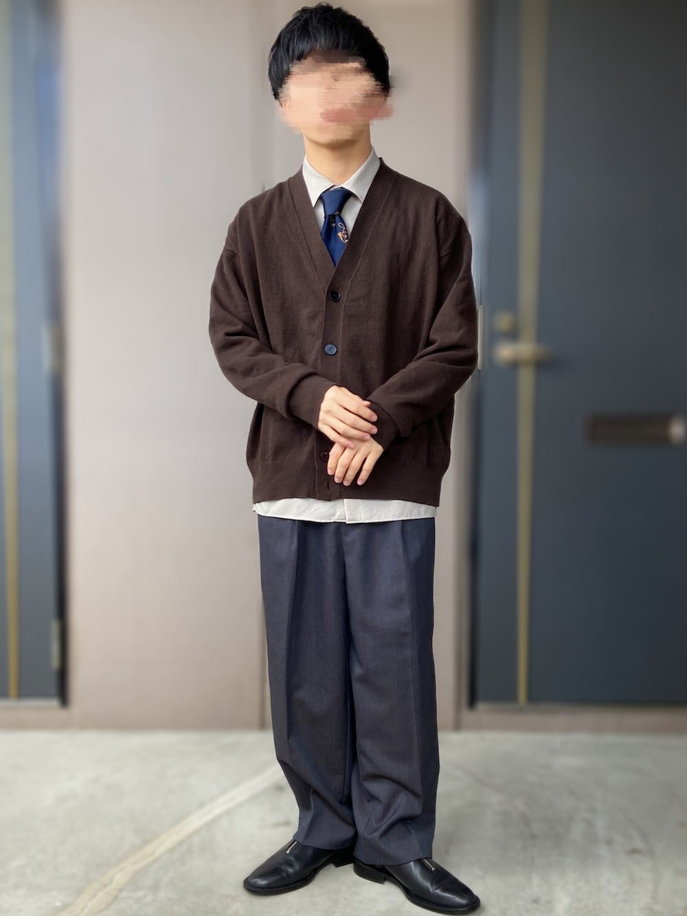 ブルー系のスラックス、ブラック系のドレスシューズ、ブラック系のカバーオールを着用したメンズの春コーディネートの3枚目の写真