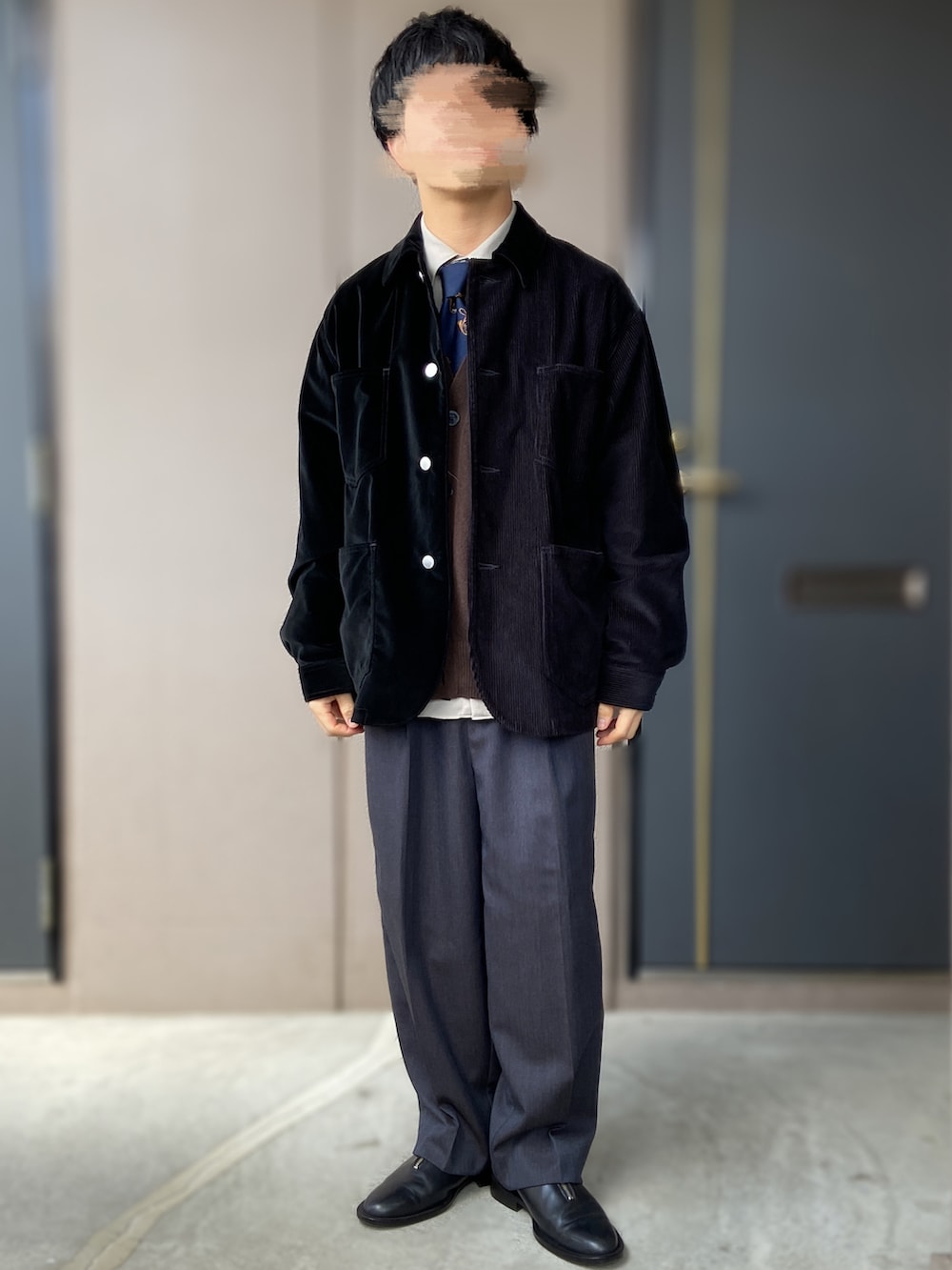 ブルー系のスラックス、ブラック系のドレスシューズ、ブラック系のカバーオールを着用したメンズの春コーディネートの2枚目の写真