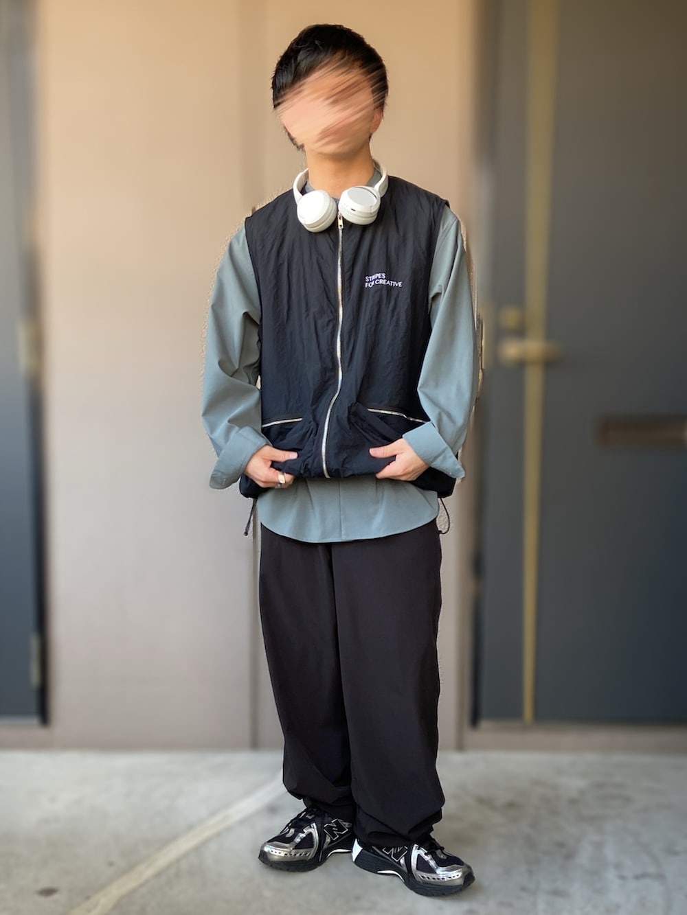 ブラック系のトップス、ブラック系のスニーカー、ブラック系のベストを着用したメンズの秋コーディネートの2枚目の写真