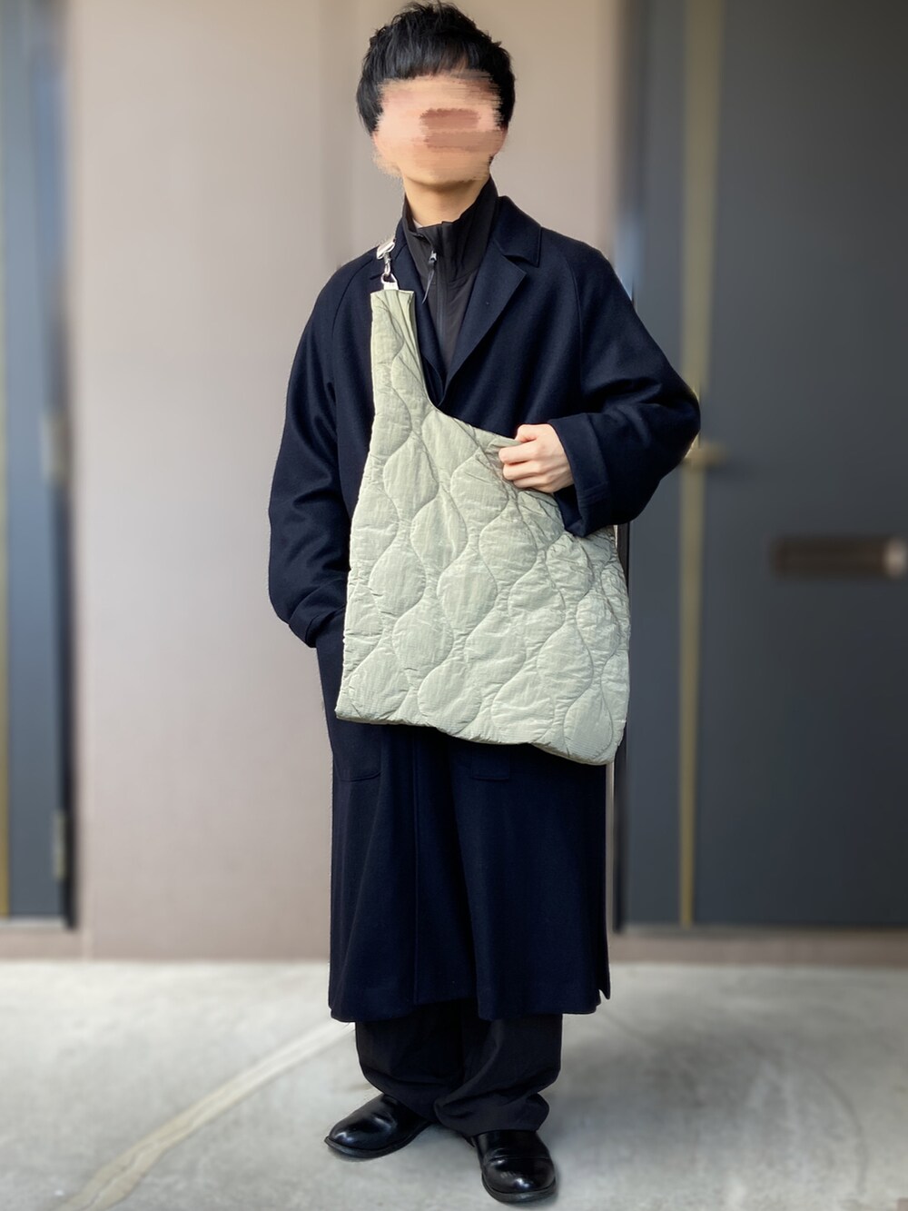 グリーン系のショルダーバッグ、ブラック系のジャケット/アウター、ブラック系のトップスを着用したメンズの冬コーディネートの2枚目の写真