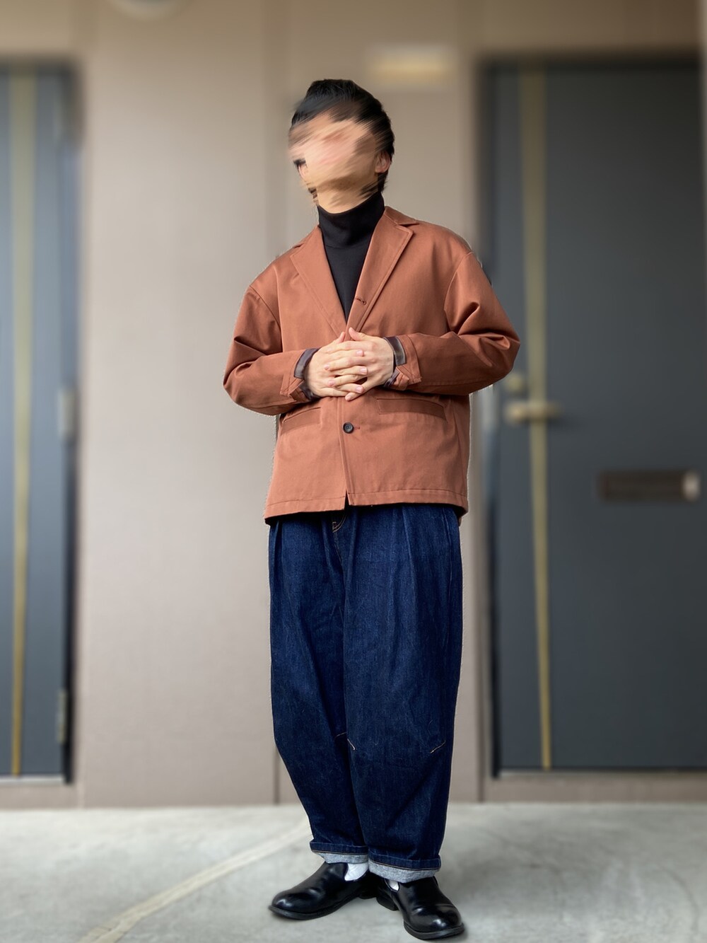 ブラック系のスリッポン、ブルー系のデニムパンツ、レッド系のテーラードジャケットを着用したメンズの春コーディネートの2枚目の写真