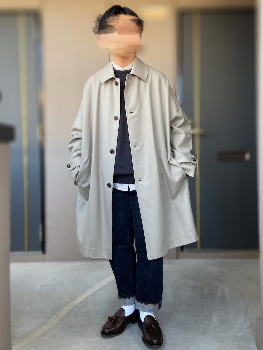 ブラウン系のローファー、ブルー系のデニムパンツ、グレー系のステンカラーコートを着用したメンズの冬コーディネートの3枚目の写真