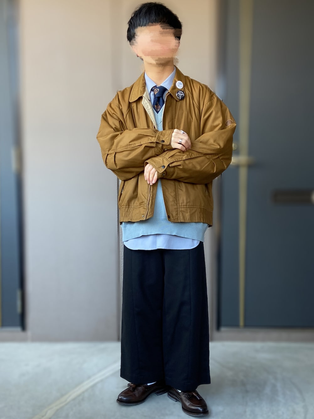 ブラウン系のローファー、ブラック系のパンツ、ブルー系のニット/セーターを着用したメンズの春コーディネートの2枚目の写真