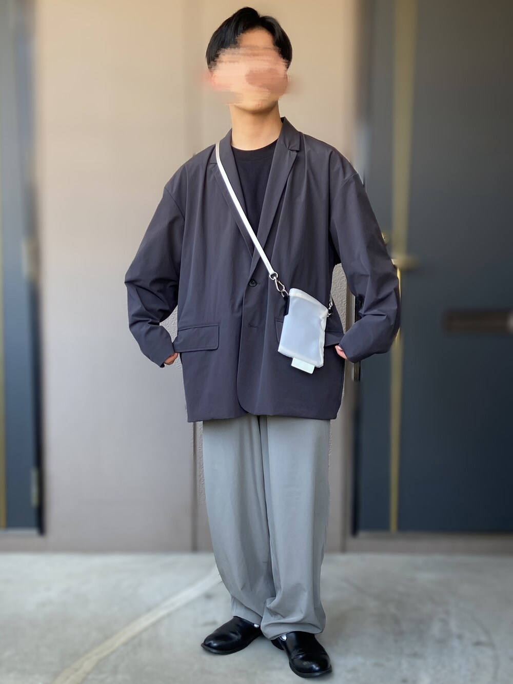 グレー系のトップス、ホワイト系のショルダーバッグ、ブラック系のTシャツ/カットソーを着用したメンズの春コーディネートの2枚目の写真