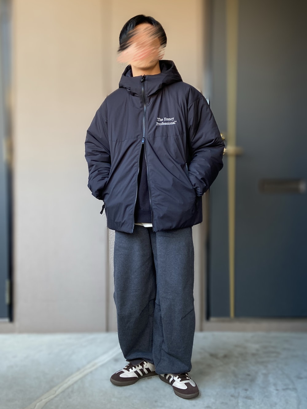 グレー系のスウェットパンツ、イエロー系のスニーカー、ブラック系のスウェットを着用したメンズの冬コーディネートの2枚目の写真