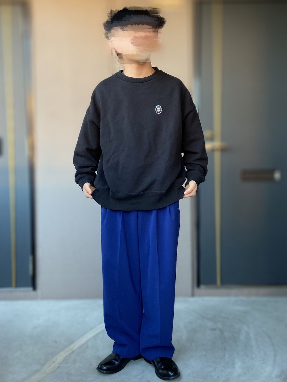 ブラック系のベスト、ホワイト系のスウェット、ブルー系のスラックスを着用したメンズの冬コーディネートの3枚目の写真