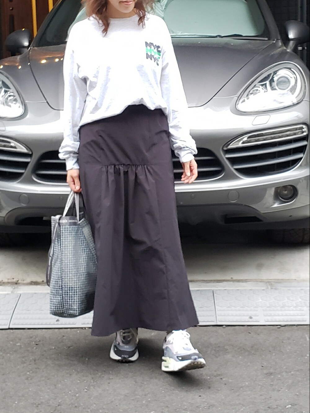 グレー系のTシャツ/カットソー、ブラック系のスカート、グレー系のショルダーバッグを着用したレディースの春コーディネートの3枚目の写真