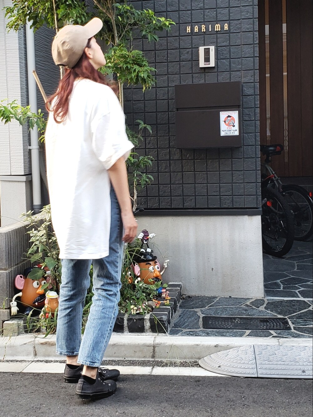 ホワイト系のTシャツ/カットソー、グレー系のスニーカー、ブルー系のデニムパンツを着用したレディースの秋コーディネートの2枚目の写真