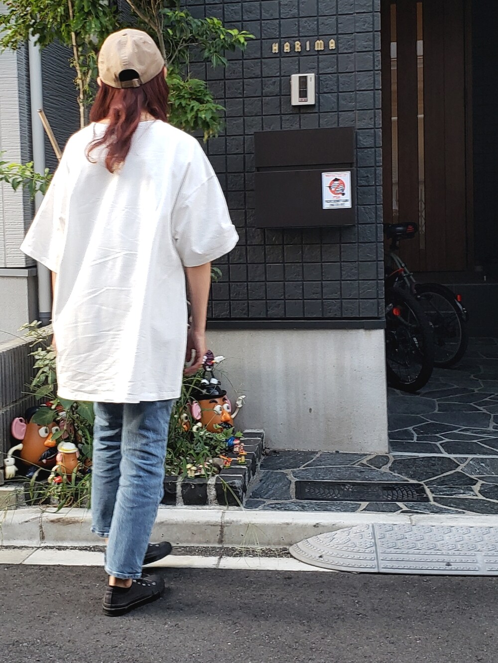 ホワイト系のTシャツ/カットソー、グレー系のスニーカー、ブルー系のデニムパンツを着用したレディースの秋コーディネートの3枚目の写真