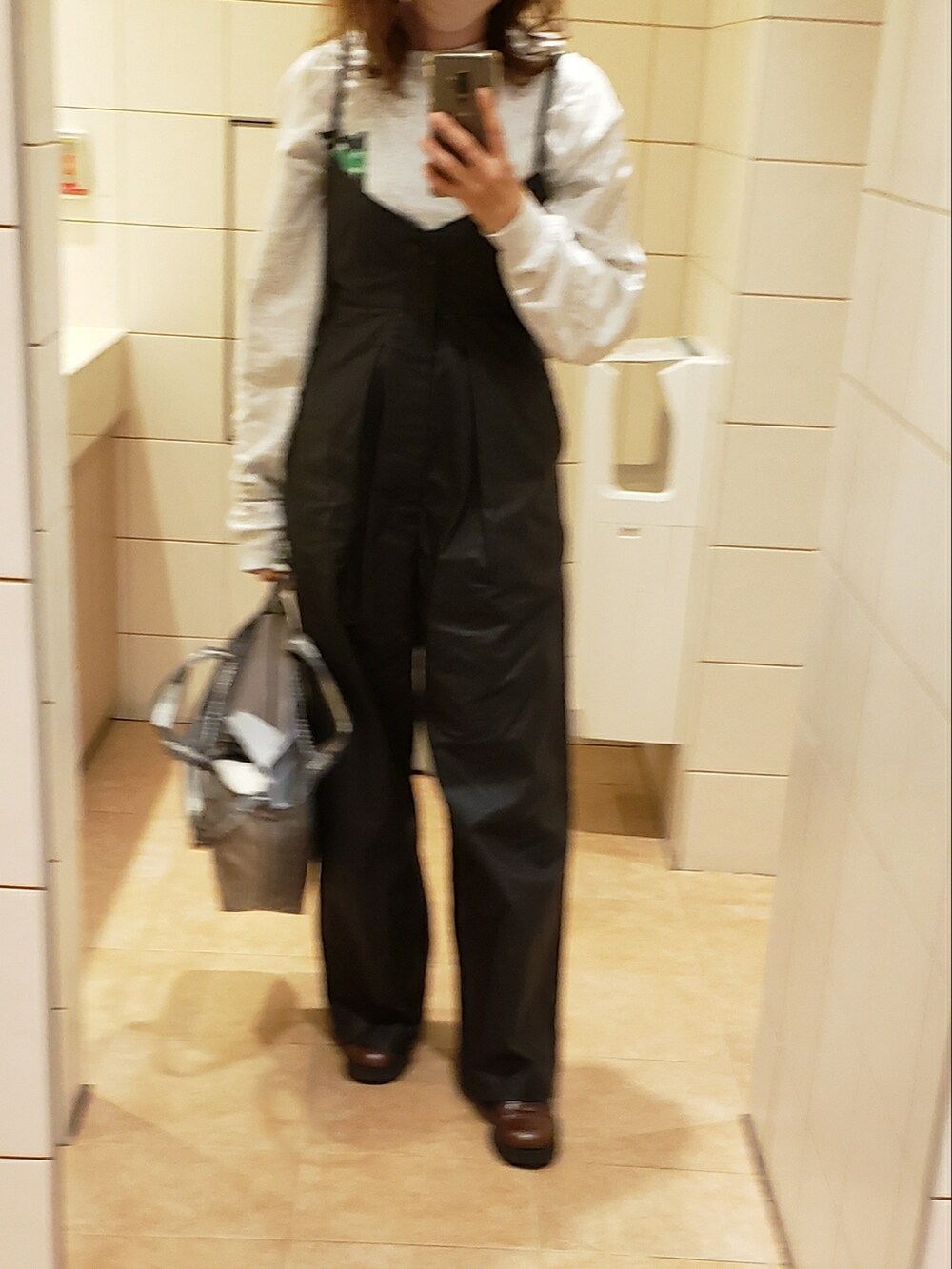 ブラック系のオールインワン・サロペット、グレー系のショルダーバッグ、グレー系のTシャツ/カットソーを着用したレディースの春コーディネートの2枚目の写真