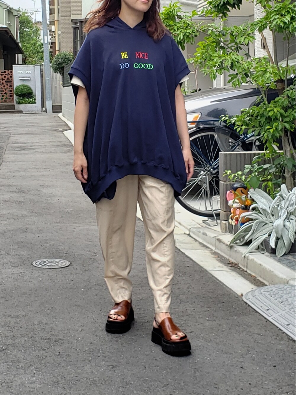 ベージュ系のカーゴパンツ、ブルー系のスウェット、ブラウン系のサンダルを着用したレディースの夏コーディネートの2枚目の写真
