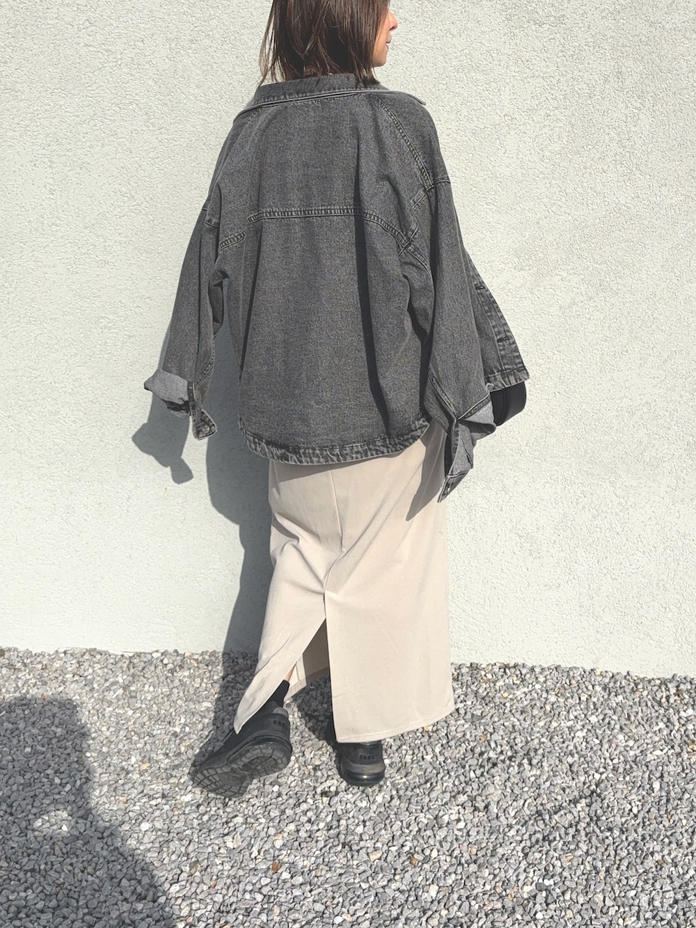 ベージュ系のワンピース、ブラック系のハンドバッグ、ブラック系のスニーカーを着用したレディースの春コーディネートの3枚目の写真