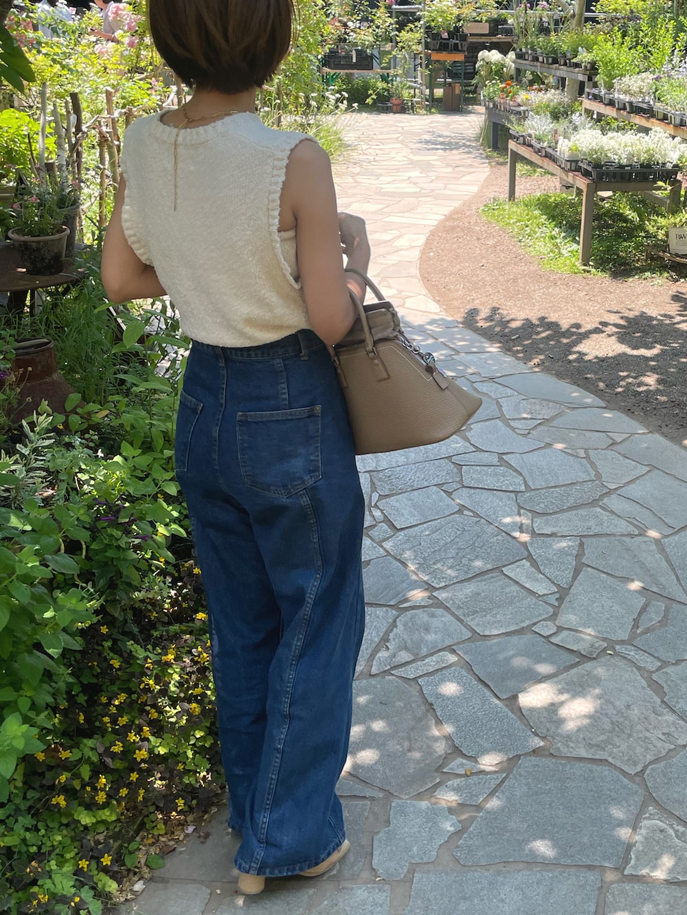 グレー系のニット/セーターを着用したレディースの夏コーディネートの2枚目の写真