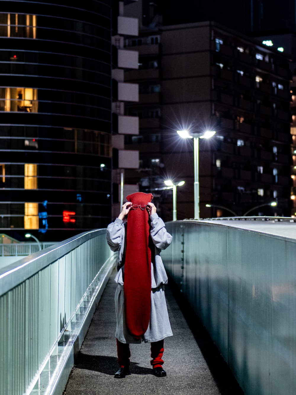 グレー系のスウェットパンツ、レッド系のニットキャップ/ビーニー、レッド系のアームカバーを着用したメンズの秋コーディネートの2枚目の写真