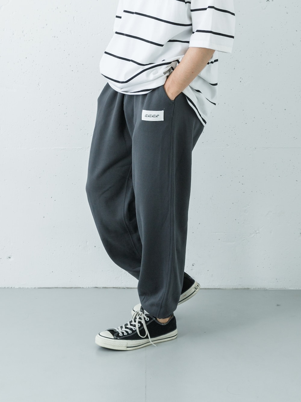 ホワイト系のTシャツ/カットソー、グレー系のスウェットパンツを着用したメンズの夏コーディネートの3枚目の写真