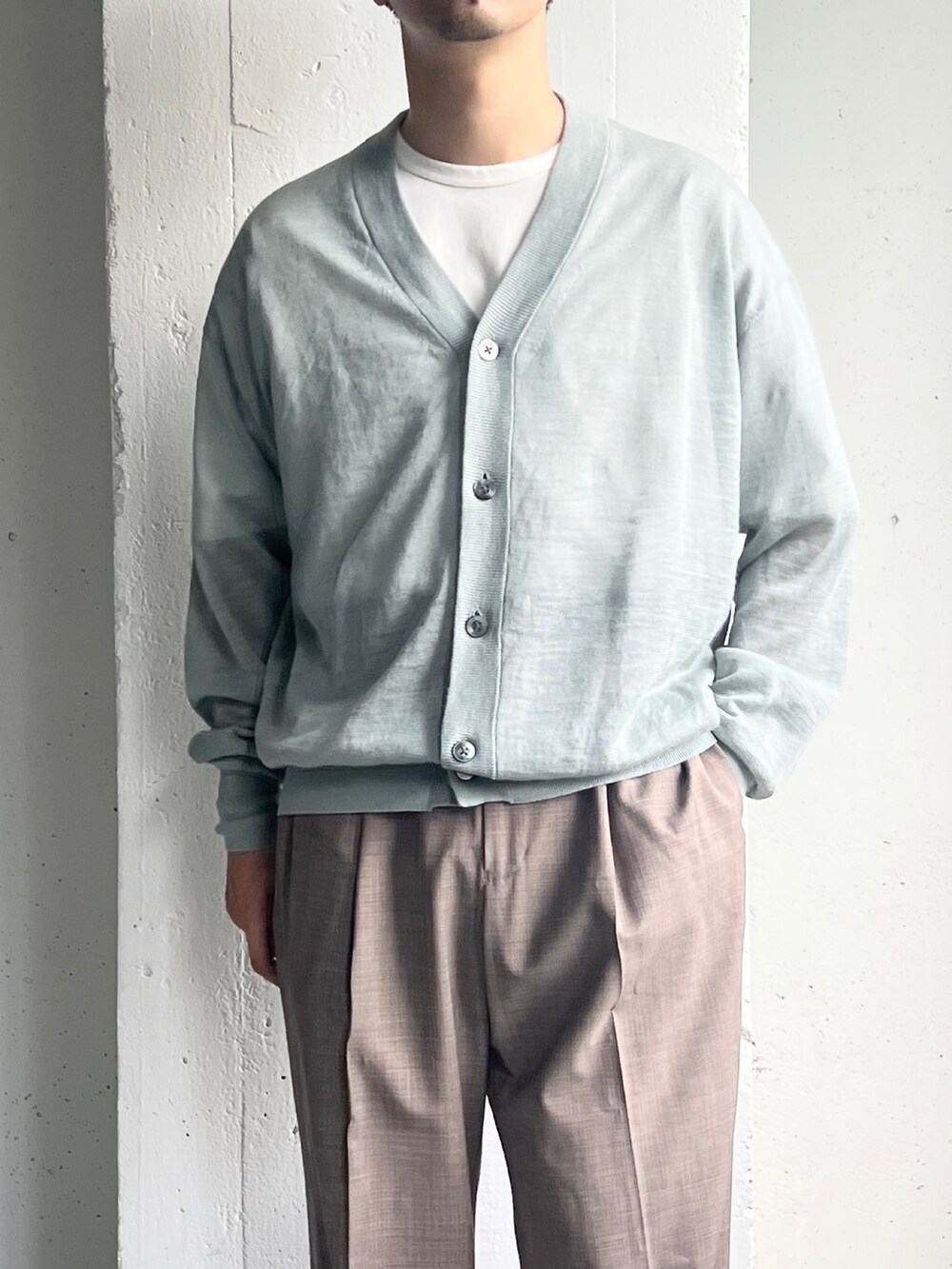 ブルー系のニット/セーター、ベージュ系のその他パンツ、ホワイト系のTシャツ/カットソーを着用したメンズの夏コーディネートの6枚目の写真