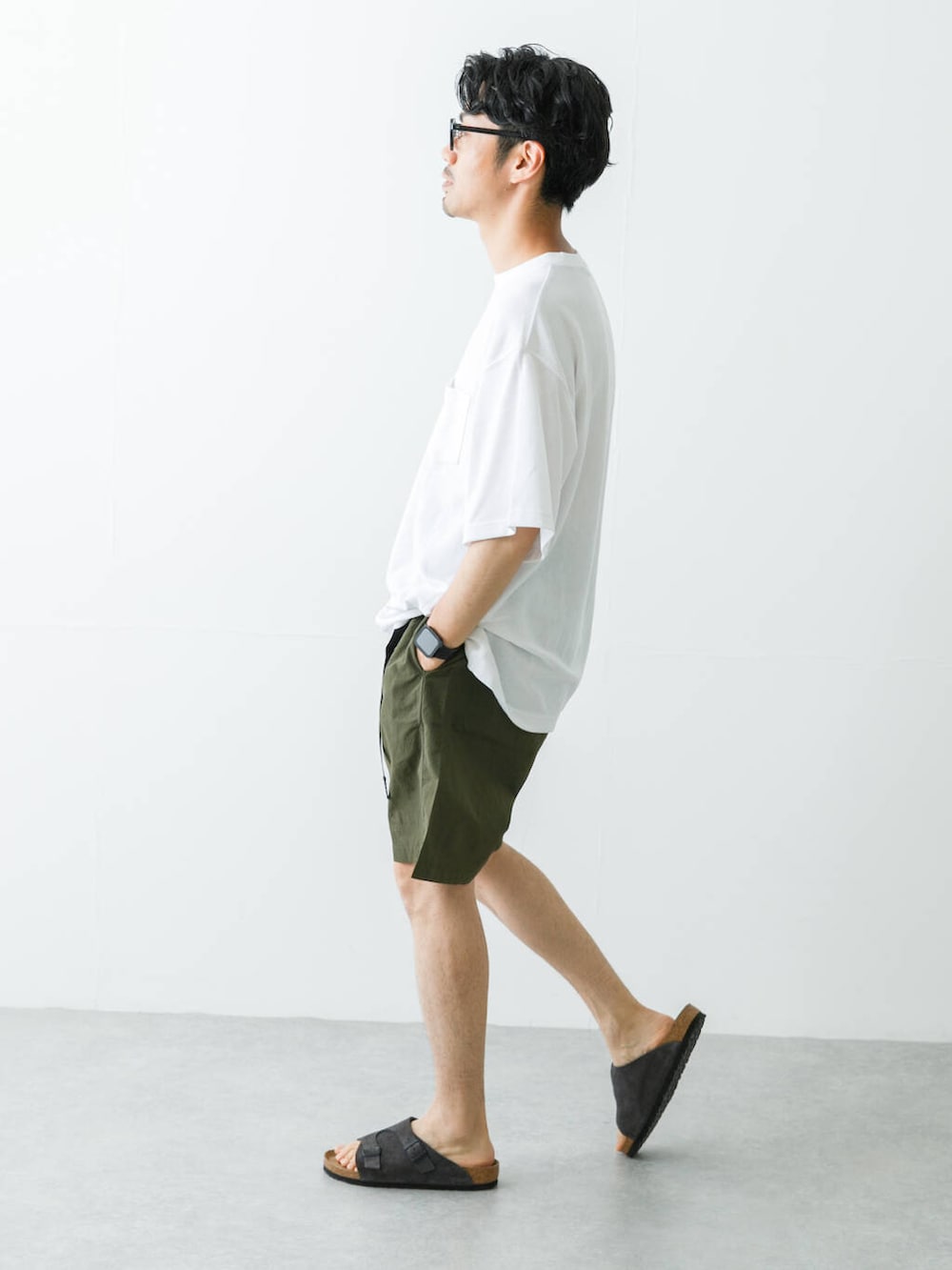 グリーン系のその他パンツ、グレー系のサンダル、ホワイト系のTシャツ/カットソーを着用したメンズの春コーディネートの6枚目の写真