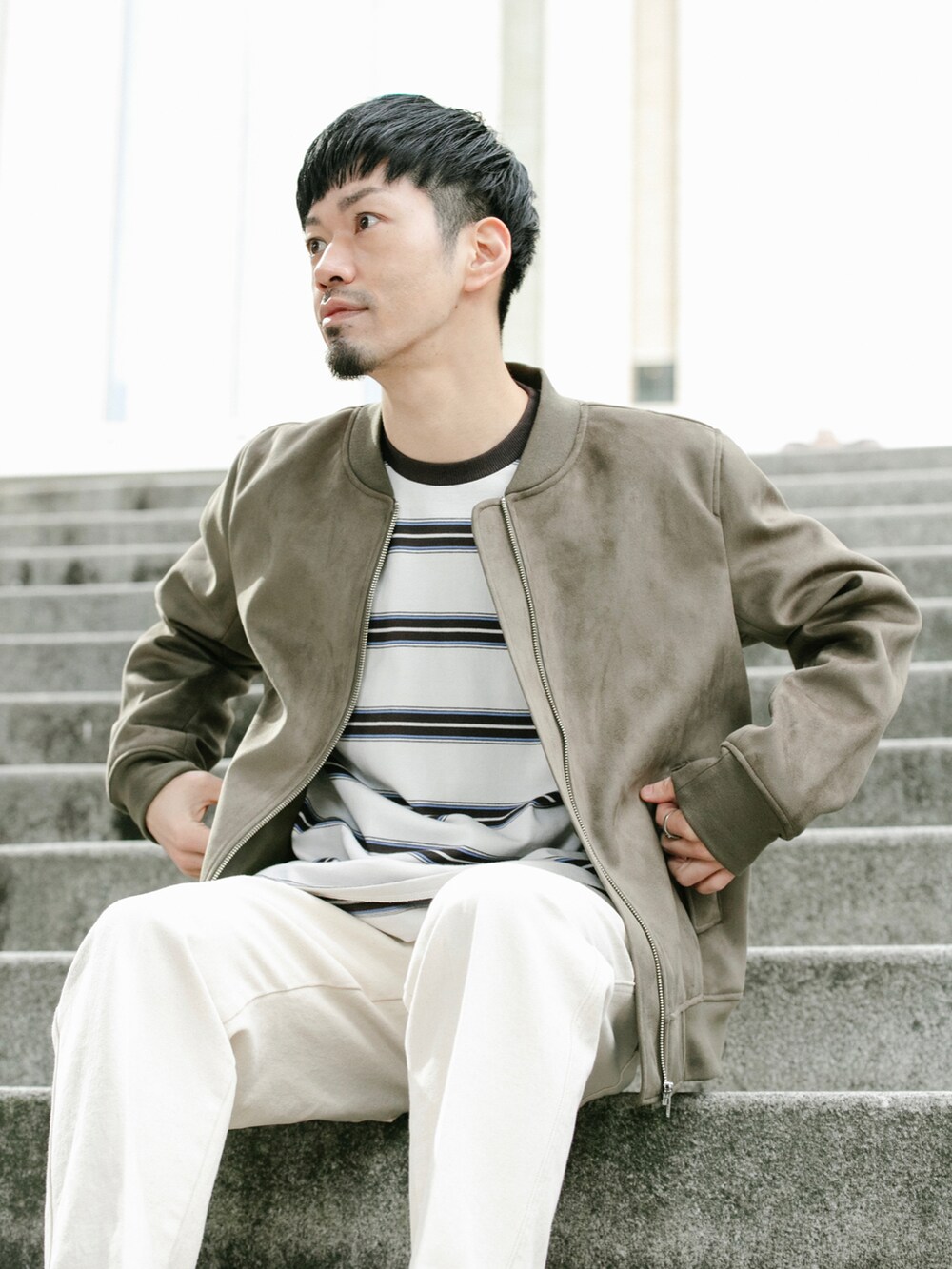 ベージュ系のMA-1、ホワイト系のデニムパンツ、ホワイト系のTシャツ/カットソーを着用したメンズの冬コーディネートの2枚目の写真