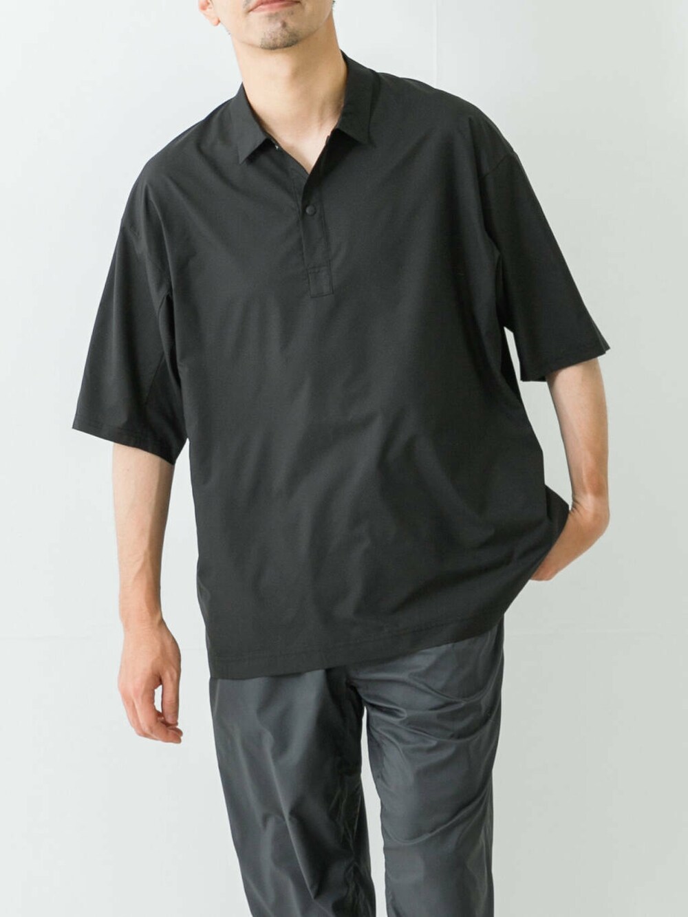 グレー系のサンダル、ブラック系のポロシャツ、グレー系のその他パンツを着用したメンズの夏コーディネートの2枚目の写真