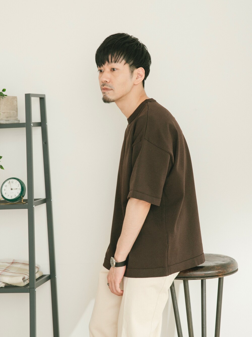 ブラウン系のニット/セーター、ホワイト系のデニムパンツ、グリーン系のその他を着用したメンズの春コーディネートの4枚目の写真