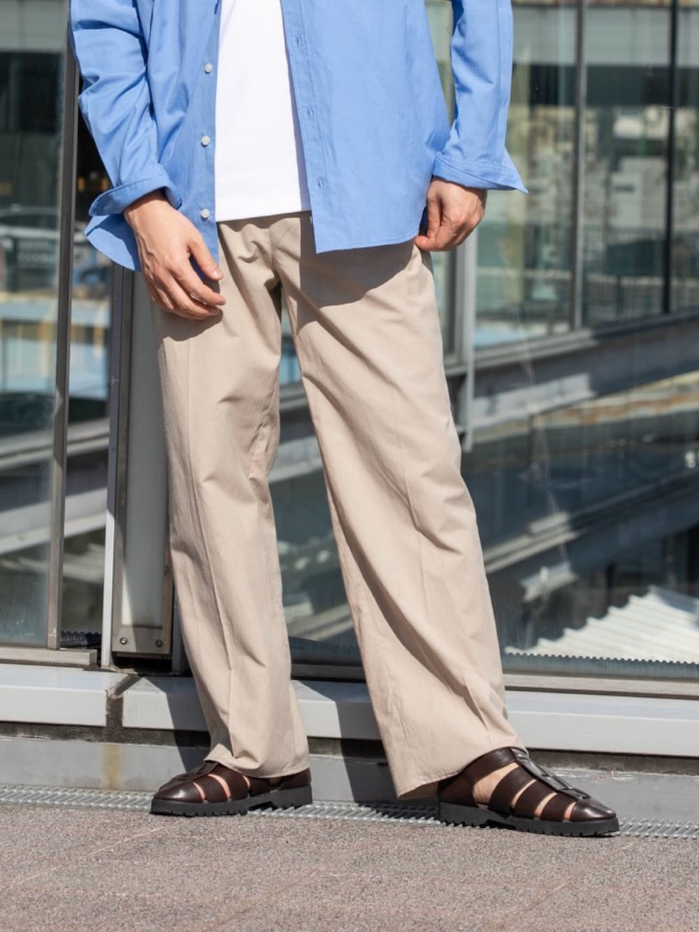 ホワイト系のTシャツ/カットソー、ベージュ系のスラックス、ブルー系のシャツ/ブラウスを着用したメンズの春コーディネートの3枚目の写真