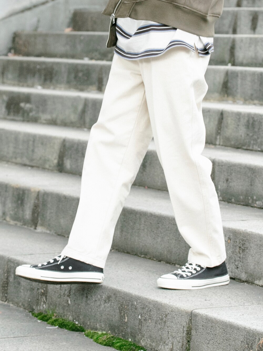 ベージュ系のMA-1、ホワイト系のデニムパンツ、ホワイト系のTシャツ/カットソーを着用したメンズの冬コーディネートの3枚目の写真