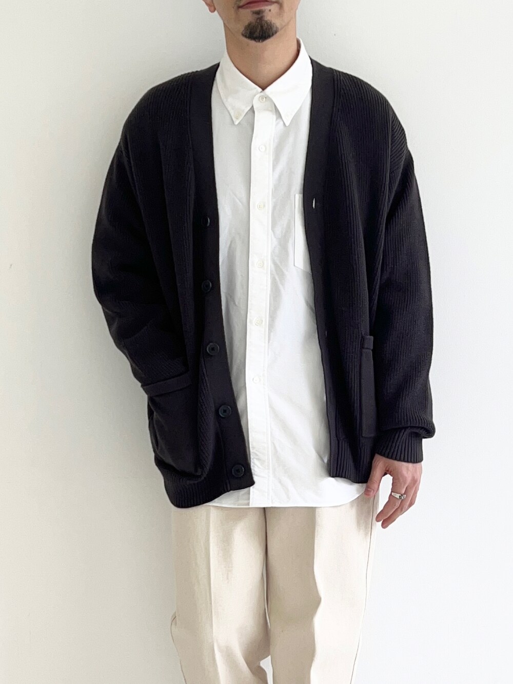 グレー系のカーディガン/ボレロ、ホワイト系のシャツ/ブラウス、ホワイト系のデニムパンツを着用したメンズの春コーディネートの4枚目の写真