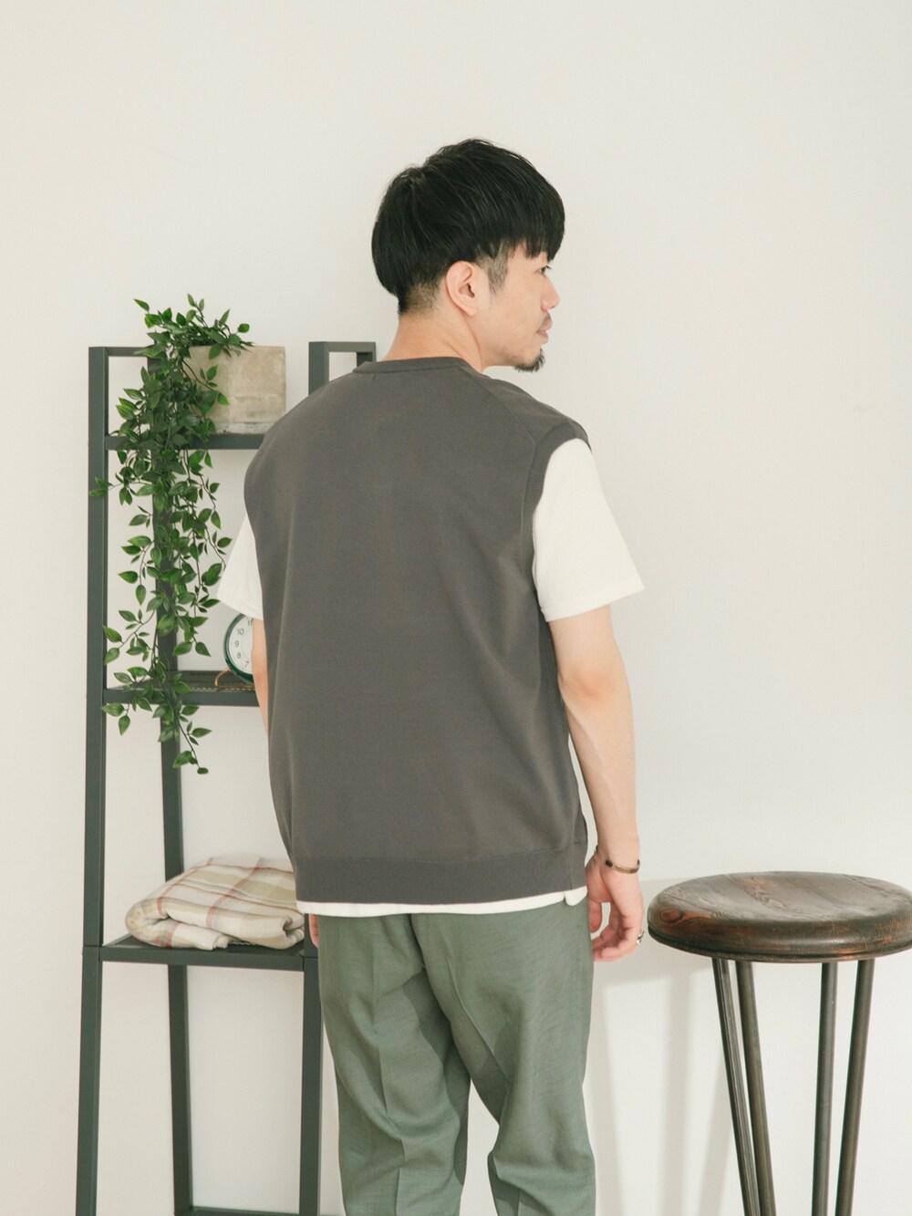 グレー系のベスト、グリーン系のスラックス、ホワイト系のその他を着用したメンズの春コーディネートの4枚目の写真