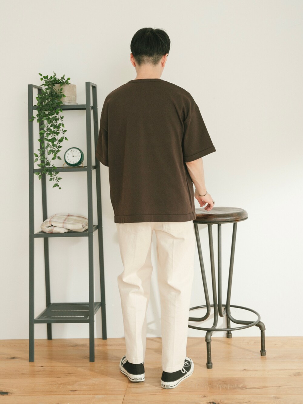 ブラウン系のニット/セーター、ホワイト系のデニムパンツ、グリーン系のその他を着用したメンズの春コーディネートの3枚目の写真